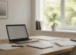 میز کار با لپتاپ و کاغذ در نور طبیعی